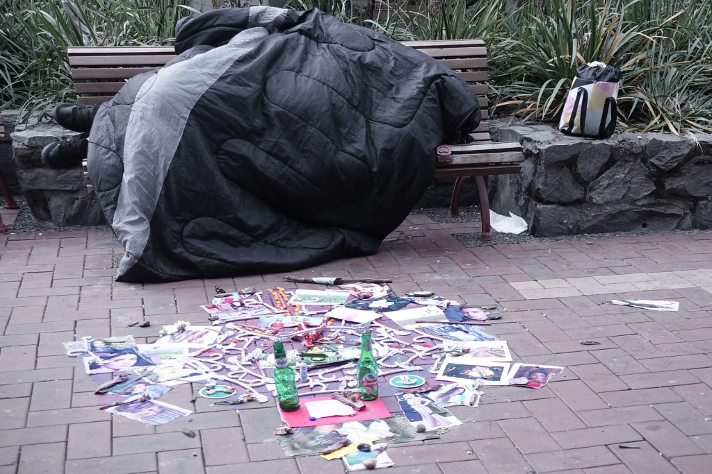 Man sleeping in bench in Cuba Street