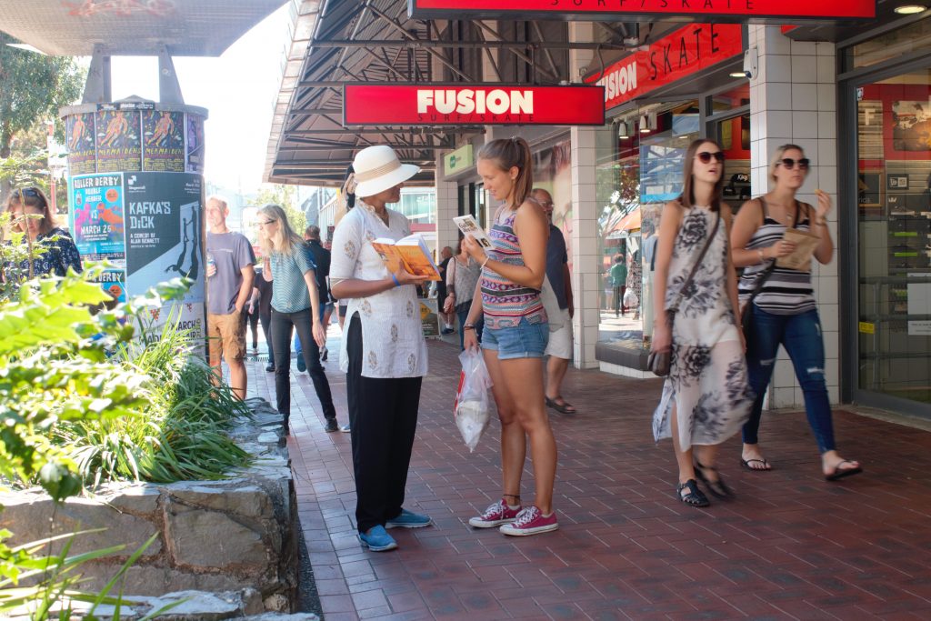 Woman giving out books in Cuba Street