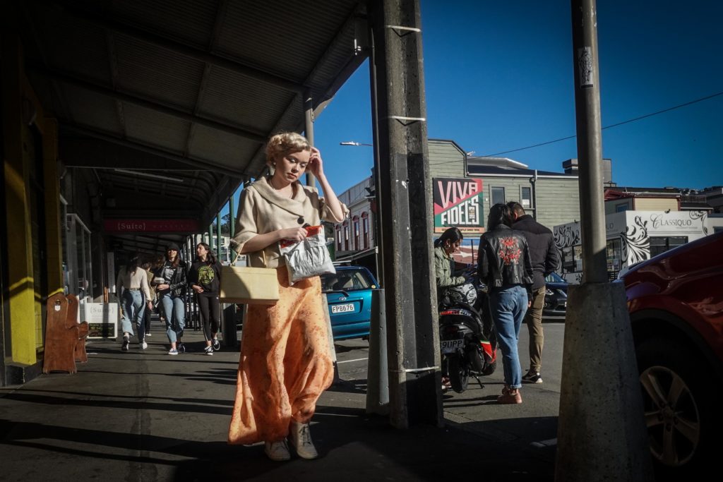 Woman in orange dress walking down Cuba Street